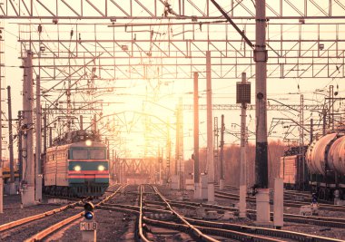 İki uzun yük treni istasyondan taşır.