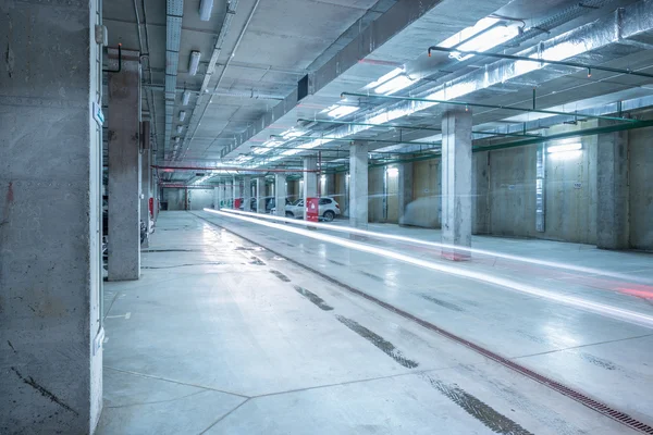 Auto verlichting in de grote ondergrondse stad parkeergarage. — Stockfoto
