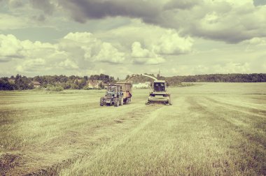 Agriculture machines collect hay.