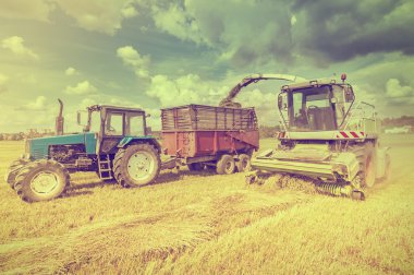 Agriculture machines collect hay.