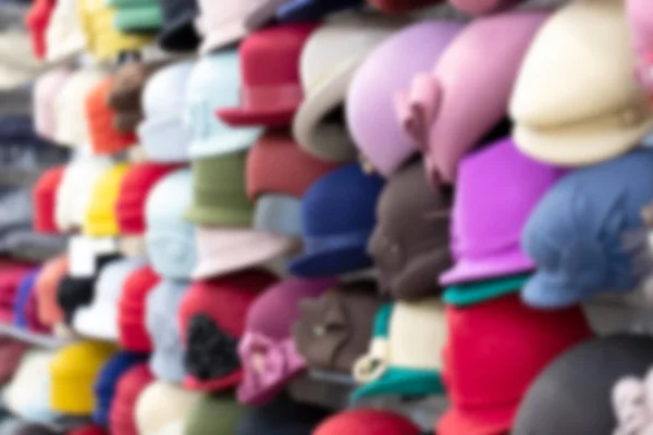 Many collection hat on rack in market. Blurred background.