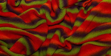 Büyük el yapımı merino yün battaniyesi, süper tombul iplik, moda konsepti. Kırmızı, yeşil ve kahverengi yün örülmüş bir battaniyenin yakın çekimi. Seçici odak