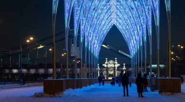 Moskova, Rusya, 05 Ocak 2021 Birçok insan bir kış akşamı arkadaşları ve çocuklu aileleriyle şehir parkında yürür. Yeni yıl tatili boyunca aktif dinlenme. Merkez eğlence parkı