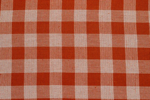 Textile background with checkered red tablecloth, top view. Texture of natural linen fabric. Selective focus. Copy space. Place for food and drink. Restaurant, menu