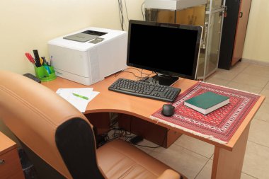 Deri koltuklu ofis masası. Masaüstü bilgisayarı, yazıcısı ve ofis malzemeleri ile çalışmak için rahat bir yer.