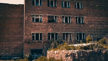 Kırık camlı, terk edilmiş bir kırmızı tuğla fabrikasının tonlu bir görüntüsü. Yıkım kavramı.