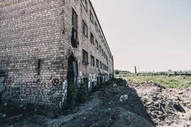 Kırık camlı, terk edilmiş bir kırmızı tuğla fabrikasının tonlu bir görüntüsü. Yıkım kavramı.