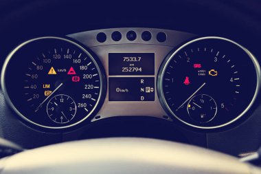 Arabanın iç kısmının klasik tonlu görüntüsü. Kontrol paneline yakın çekim. Araç kontrol paneli detayları. Seyahat, araba sigortası, satış kavramı