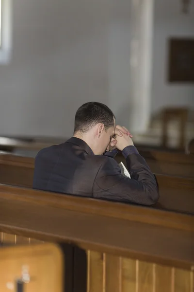 Homem orando na igreja Fotografia De Stock