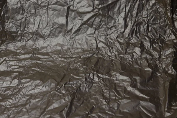 Silver crumpled foil paper texture.