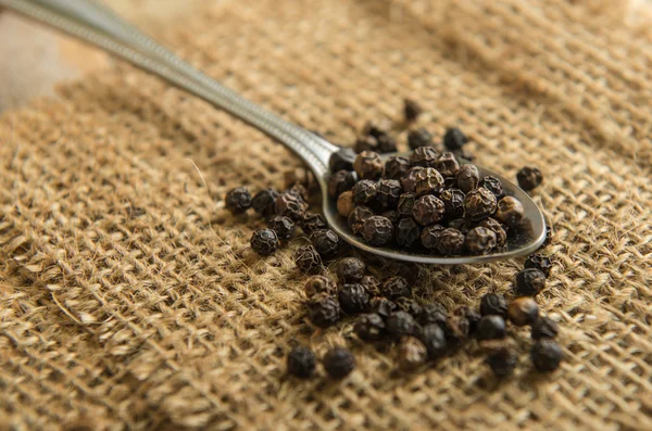 Peppercorn in lepel op tafel — Stockfoto