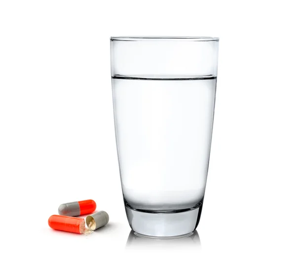 Vaso de agua y pastillas aisladas sobre fondo blanco — Foto de Stock