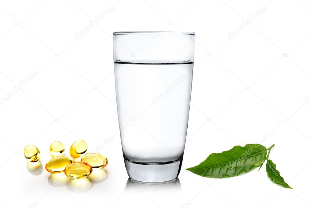 Glass of water wiith green tea leaf and fish oil isolated on whi