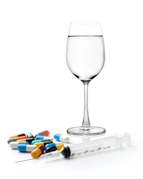 Glas water spuit en kleurrijke pil en capsules op wit — Stockfoto