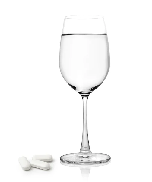 Szklanka wody i tabletki izolowane na białym tle — Zdjęcie stockowe