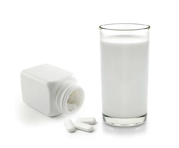 Pillola e bicchiere di latte isolato su sfondo bianco — Foto Stock