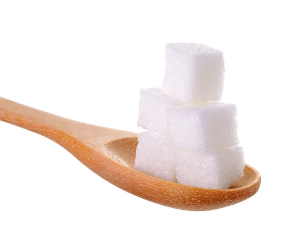 Tahta kaşık beyaz arka plan üzerinde izole küp şekerler — Stok fotoğraf