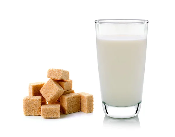 Vidro de leite e cubos de açúcar de cana isolado em backgrou branco — Fotografia de Stock