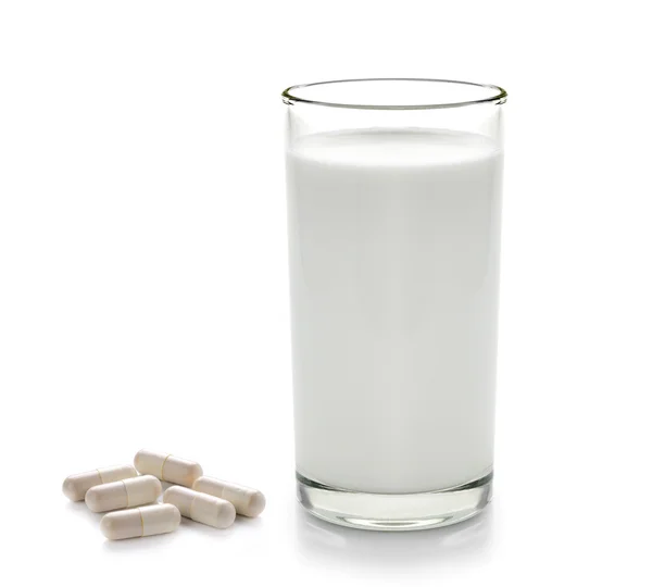 P-piller och glas mjölk isolerad på vit bakgrund — Stockfoto