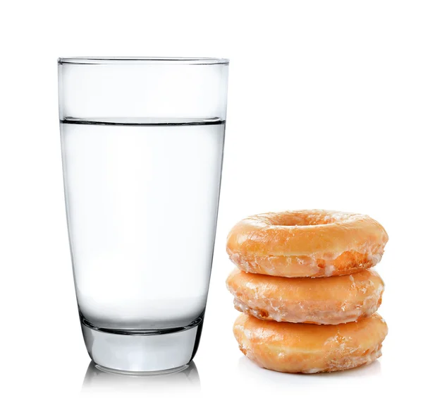 Pączki i szklankę wody na tle na białym tle — Zdjęcie stockowe