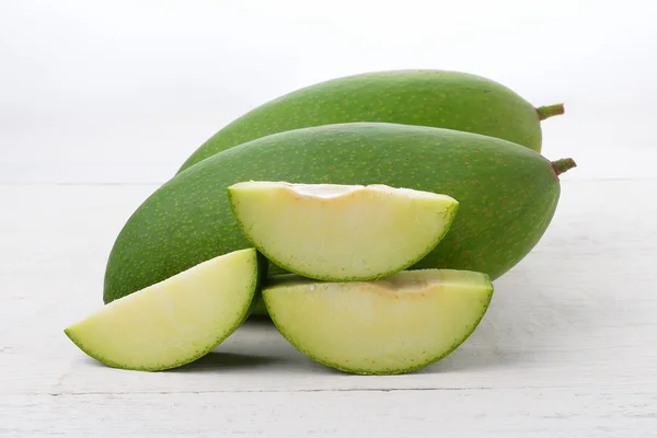 Čerstvé zelené mango na bílém dřevě — Stock fotografie