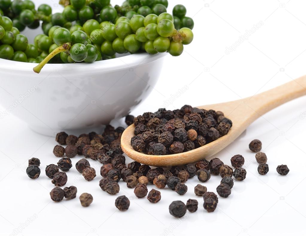 Black pepper seeds and fresh pepper on white background