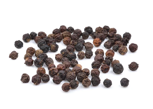 Семена черного перца на белом фоне — стоковое фото