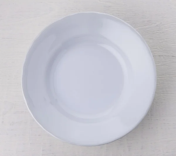 Piatto vuoto in ceramica bianca su tavolo in legno — Foto Stock
