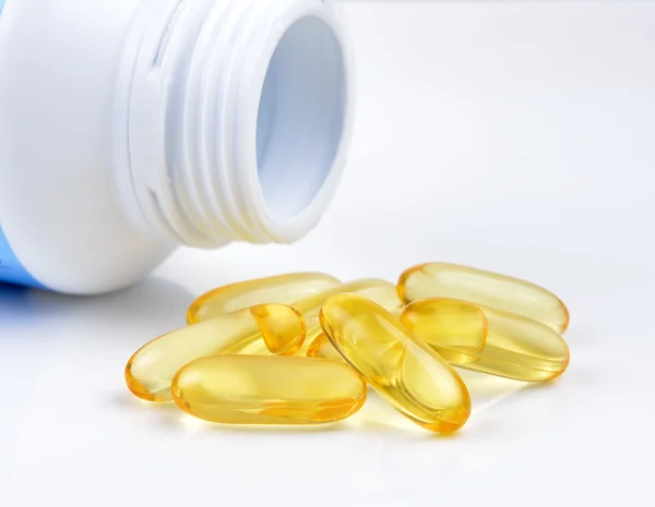 Fish oil capsules and container — Stock Photo, Image