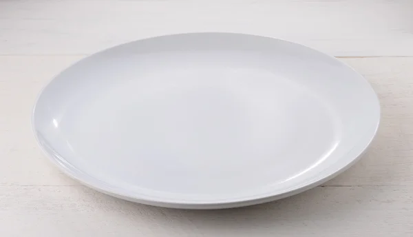 Lege witte keramische plaat op houten tafel — Stockfoto