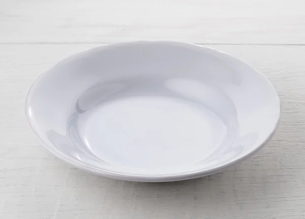 Piatto vuoto in ceramica bianca su tavolo in legno — Foto Stock