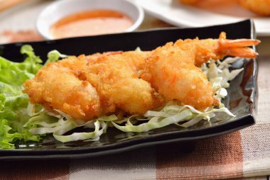 Kızarmış karides beyaz tabakta sebze ile