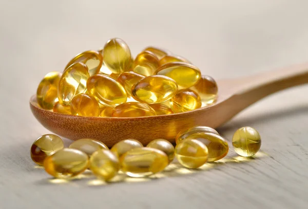 Fish oil capsules in a spoon — Stock Photo, Image