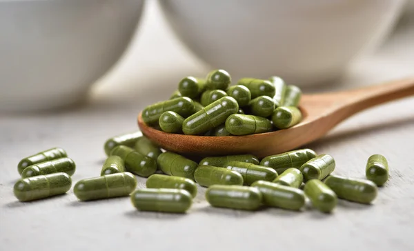 Moringa capsule pillen in de woodspoon — Stockfoto