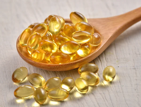 Fish oil capsules in a spoon — Stock Photo, Image