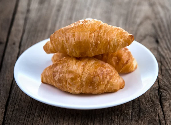 Croissant on wooden table — Stock Photo, Image