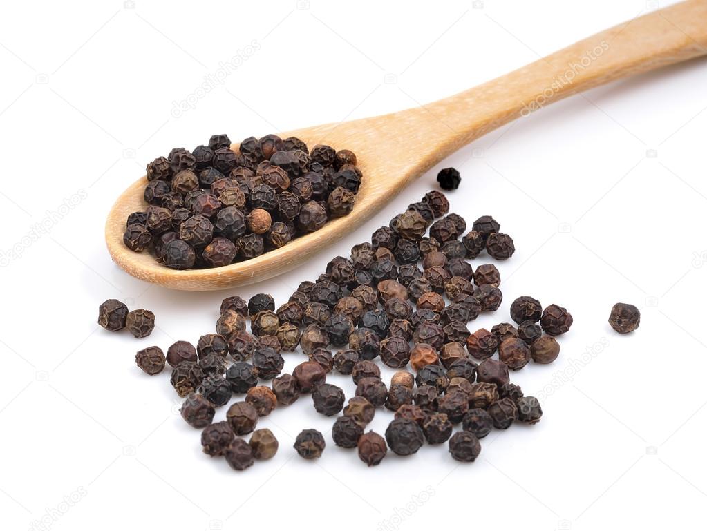 Wooden spoon and black peppercorn on white background