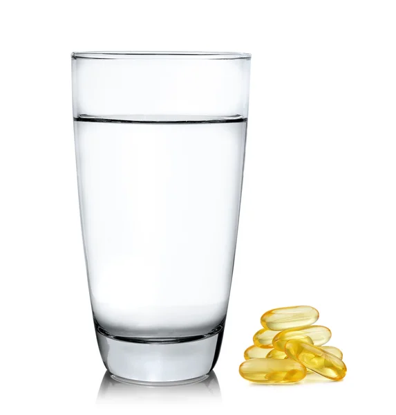 Bicchiere di acqua e olio di pesce isolato su sfondo bianco — Foto Stock