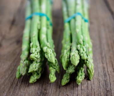 Ahşap arka planda taze yeşil kuşkonmaz