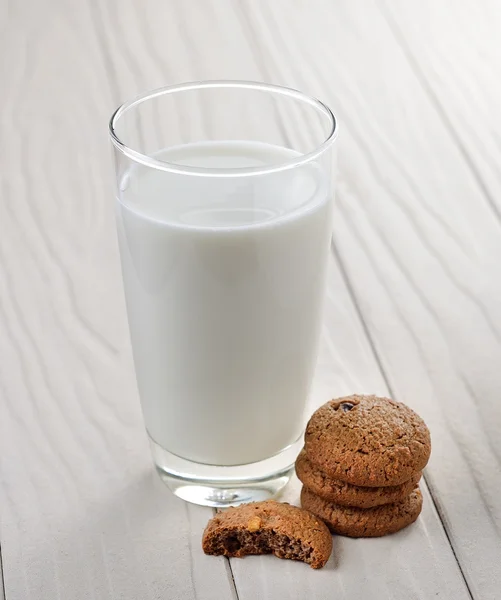 Biscotti e latte su sfondo bianco di legno — Foto Stock