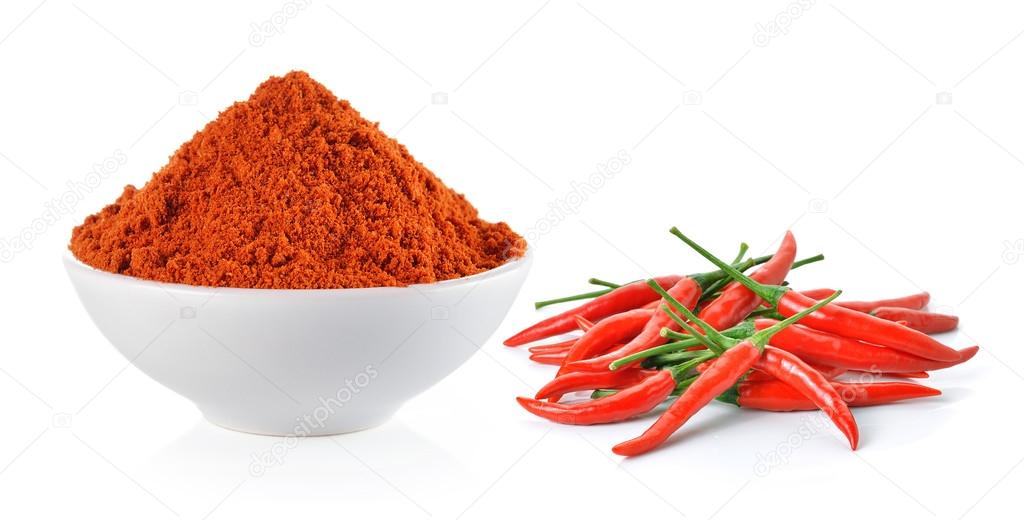 Powdered dried red pepper and red chili peppers in a white bowl