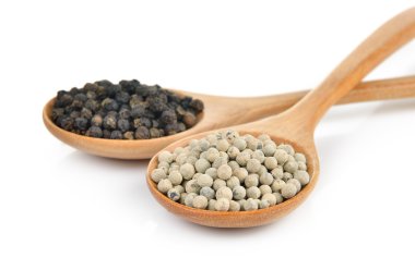 beyaz zemin üzerine tahta kaşık biber