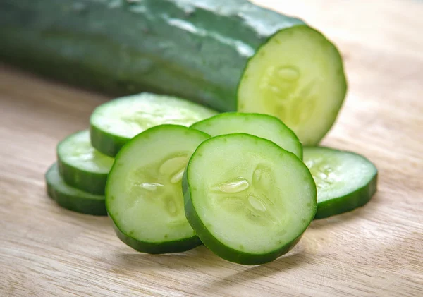 Fatias de pepino fresco no fundo de madeira — Fotografia de Stock