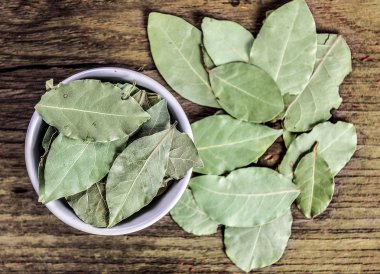 defne yaprağı ahşap üzerine beyaz seramik kase