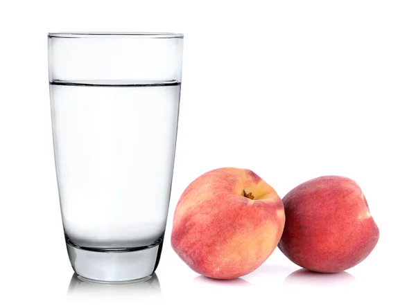 Glas water en perzik met geïsoleerde op witte achtergrond — Stockfoto