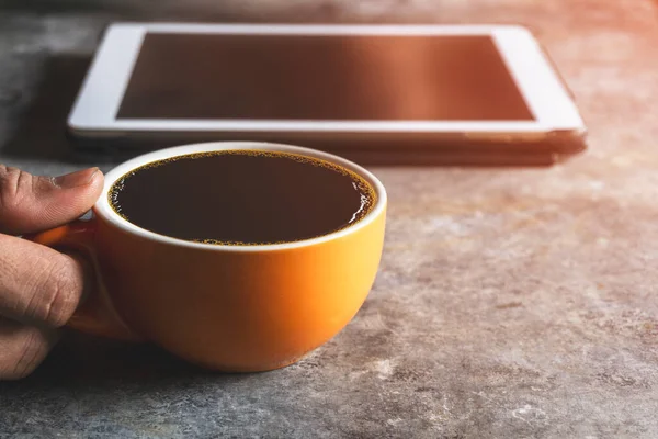 Kahve molası. Tablet arkaplanlı sarı kahve.