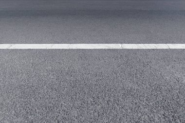 Beyaz trafik hatları olan asfalt bir sokak yolu boş bir arka plandır. Şehir karayolu ve köy yolu kavramı.