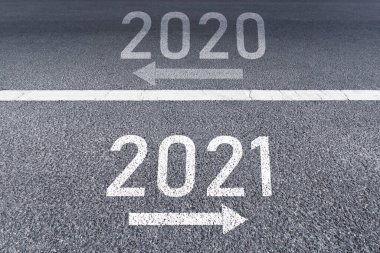 İşaret oku 2020 yılına geri döndü ve 2021 'de asfalt yol arka planında yeni yıl vizyonu 2021' de yazıldı..