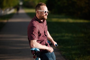 Bisikletli ve sırt çantalı yakışıklı bir erkek.