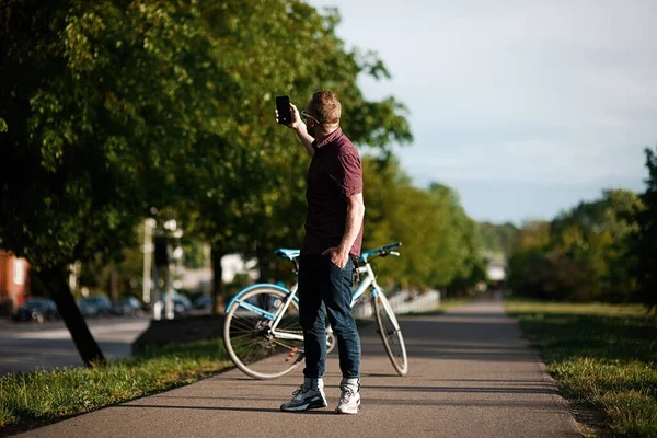 Bisikletli ve sırt çantalı yakışıklı bir erkek.